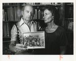 Mr. Wajzman Holds a Photograph of his Family while Standing Next to Wife