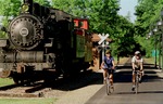 Two Bikers pass an old locomotive on the Kokosing Gap Trail