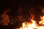 Fans stand by a bonfire