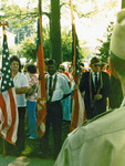 Three people hold flags at Memorial Service